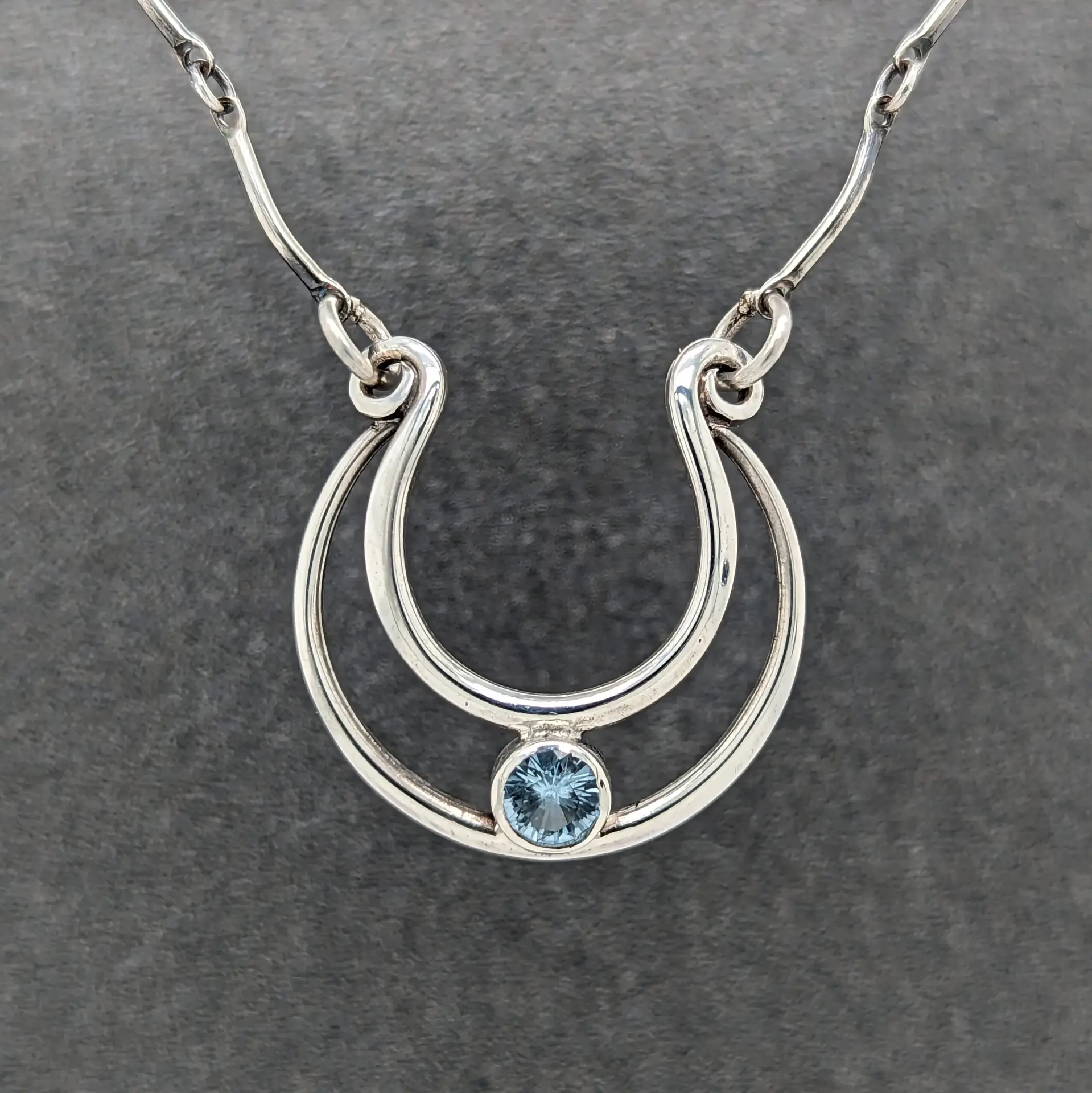 Topaz Horseshoe Necklace Modern Heirloom® Studio Hand engraved sterling silver horseshoe necklace featuring a blue topaz gemstone by Modern Heirloom® Studio